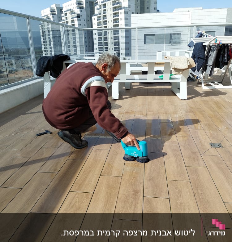 אדם מנקה רצפה עם מכשיר חשמלי כחול